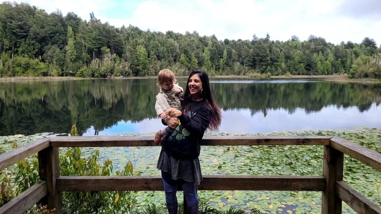 Una mamá con su hija frente al lago